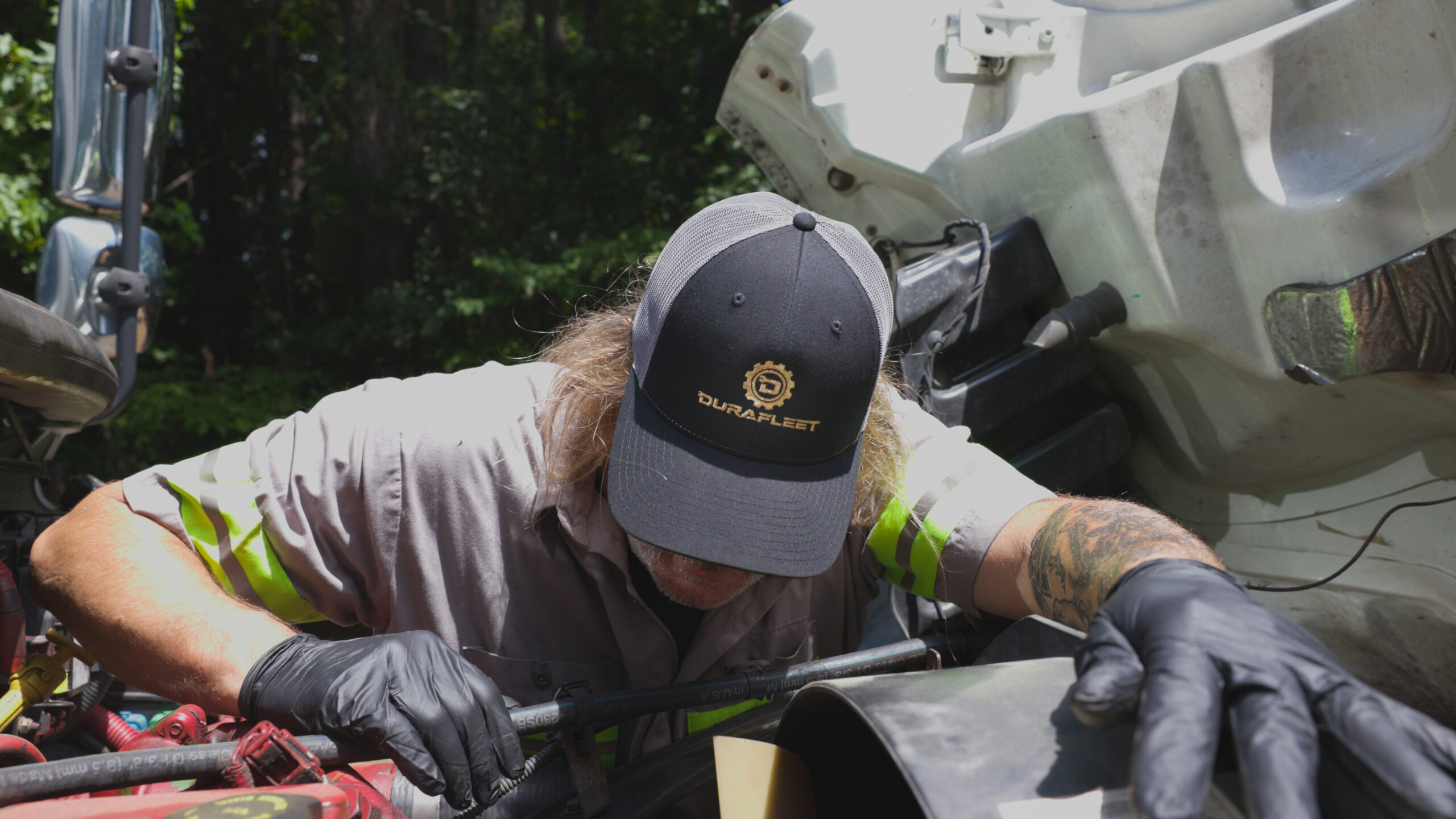 DuraFleet technician performing on-site hydraulic hose repair on a commercial truck to keep equipment running