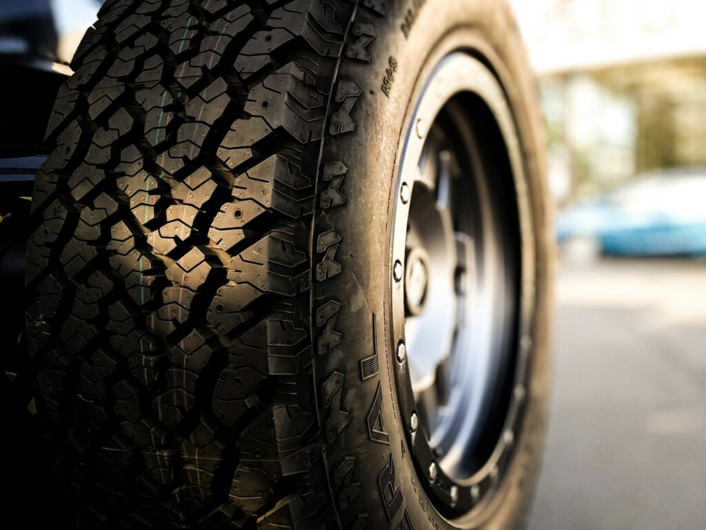 A tire and rim that looks as though it has plenty of tread left on it.
